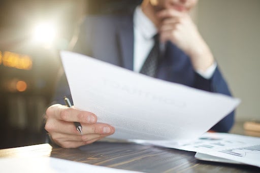 um homem olhando uma certidão negativa de débitos